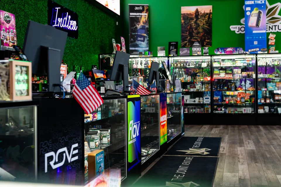 The service counter under the Indica neon, where budtenders talk customers through the menu.
